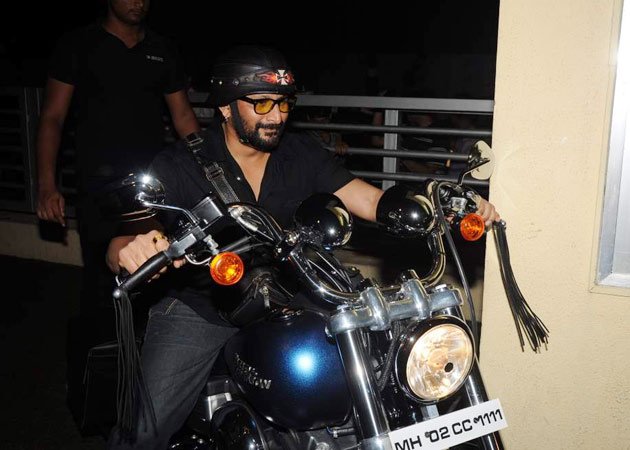 Bollywood actor Arshad Warsi riding a bike