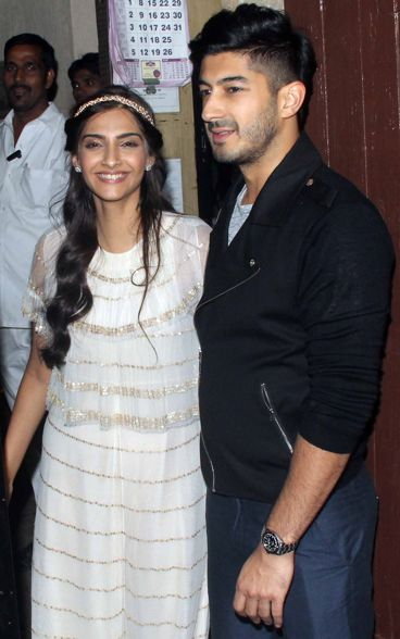 Sonam Kapoor in a long white dress, accessorized with a gold head bandwith Mohit Marwah at Anil Kapoor birthday bash