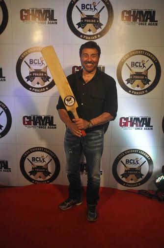 A smiling Sunny Deol with a bat