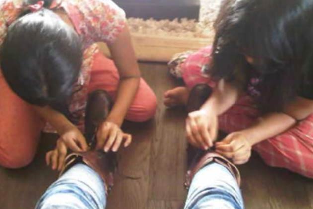 Children tying Bipasha Basu;s shoe lace